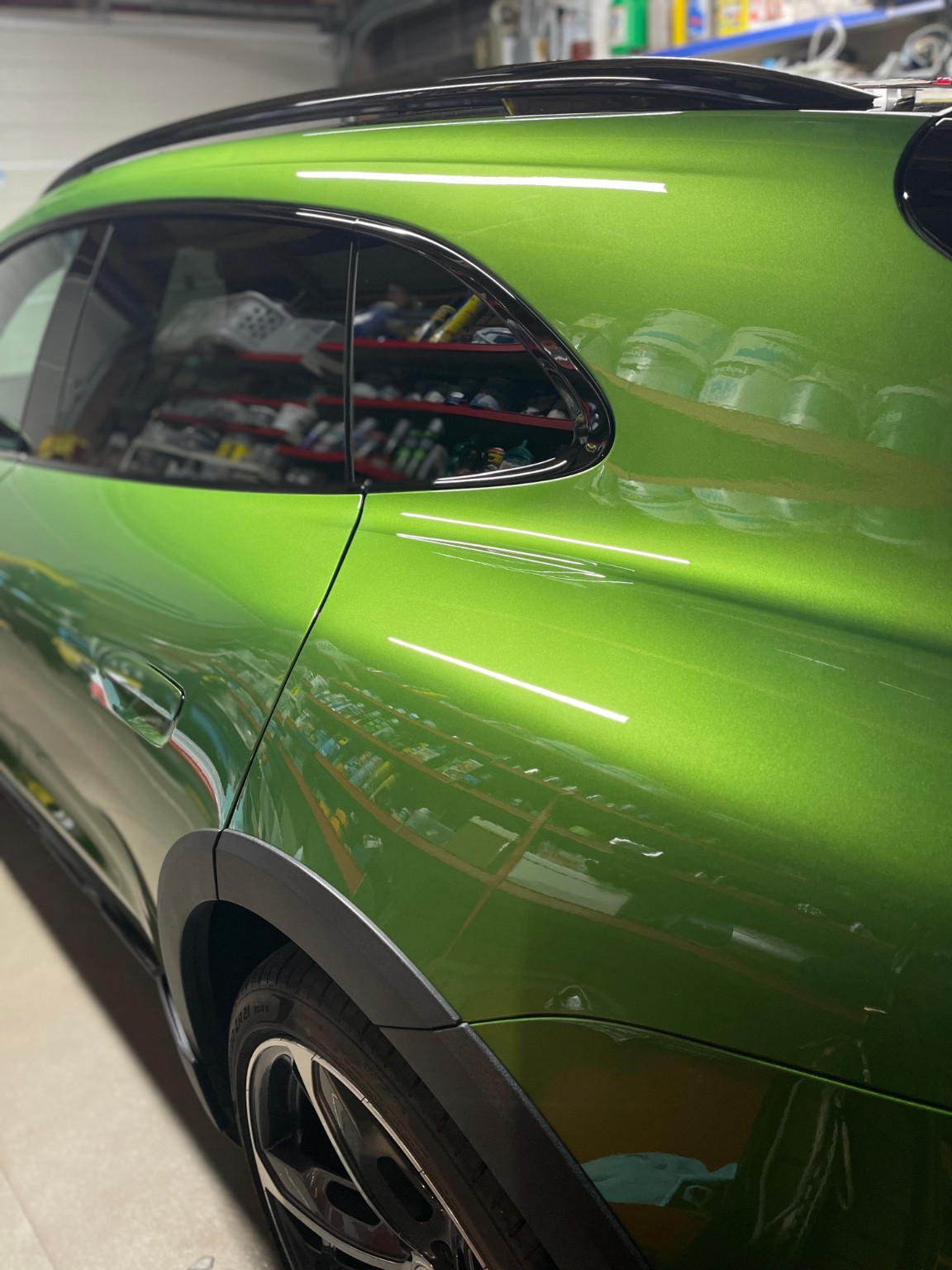 Glossy green car paint finish photographed in the workshop
